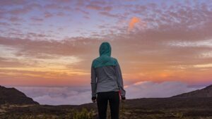 young woman standing on mountains look at clouds